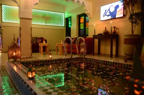 马拉喀什Riad Bab Nour的客厅的游泳池,在水中放蜡烛