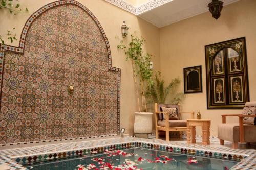 马拉喀什Riad Bab Nour的客厅设有游泳池,位于带墙壁的房间