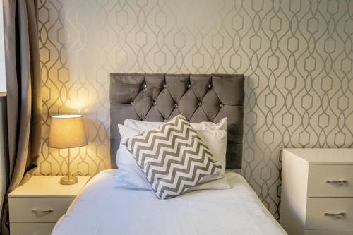 奥尔顿天使酒店的一张带灰色床头板和枕头的床