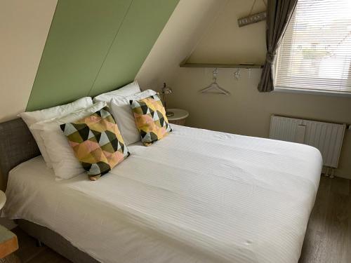 内斯Rose Cottage B&B的一间卧室配有带白色床单和枕头的床。