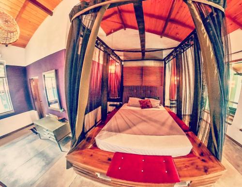 本托塔Red Coconut Villa的一间卧室,卧室内配有一张天蓬床
