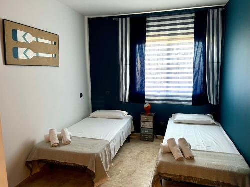 圣卡洛斯拉腊皮塔Golden Beach Sant Carles de La Ràpita的配有两张床铺的蓝色墙壁和窗户