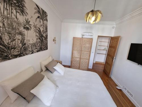 昂吉安班斯Appartement Enghien-les-Bains的卧室配有一张白色大床和电视。