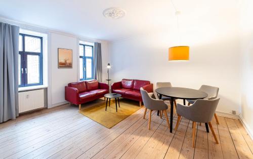 哥本哈根Go Hotel Saga的客厅配有桌子和红色沙发