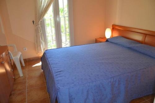 韦尔瓦Luxury Apartment in Marina de Isla Canela- Beach Front的一间卧室设有蓝色的床和窗户。