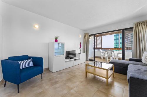 阿雷西费Apartamentos Arrecife Playa的客厅配有蓝色的沙发和电视