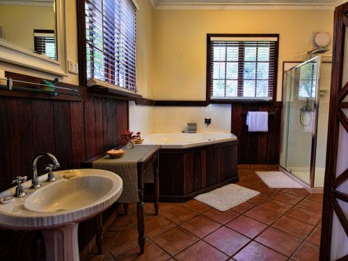 布里奇顿布里奇敦橡树巴恩木屋的带浴缸和盥洗盆的大浴室