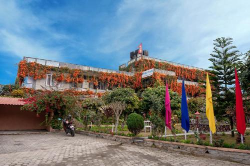 博卡拉雪人酒店的一座花朵覆盖的建筑,前面有旗帜