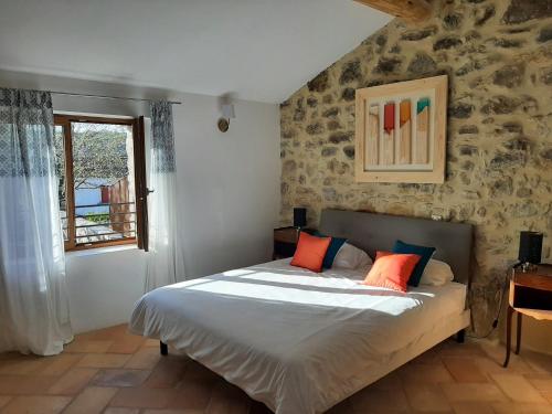 瓦隆蓬达克Bastide du Barry - Centre historique de Vallon Pont d'arc的一间卧室配有带橙色和蓝色枕头的床