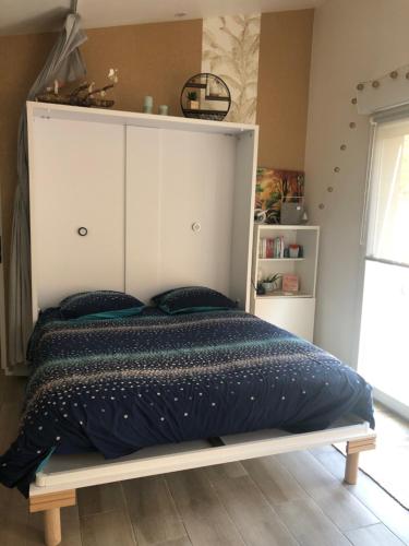 图卢兹Au Petit C'Alain的一间卧室配有一张带白色床头板的大床