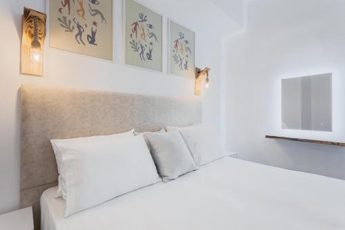 卡尔帕索斯Alpha & Omega的客房内的白色床和白色枕头