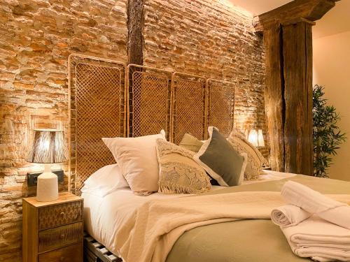 毕尔巴鄂Ribera AC by Staynnapartments的一间卧室设有一张带砖墙的大床