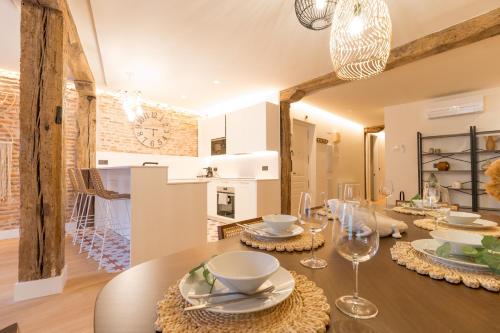 毕尔巴鄂Ribera AC by Staynnapartments的用餐室配有木桌、盘子和玻璃杯