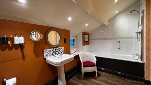 朗康​​普顿红狮旅馆的浴室配有盥洗盆和浴缸。