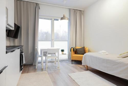 埃斯波Forenom Serviced Apartments Espoo Saunalahti的卧室配有1张床、1张桌子和1把椅子