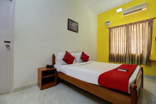 钦奈Infosys Thoraipakkam Near Ecr Beach的一间卧室配有一张铺有红白色床单的床和一扇窗户。