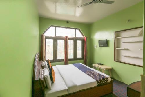 斯利那加SPOT ON Valley Meadow的一间卧室设有绿色的墙壁和一张带窗户的床
