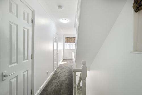 埃奇韦尔Roomy 3 bedroom house, 2 baths的一条带白色墙壁和门的走廊