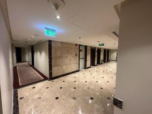 麦地那Emaar Elite Al Madina Hotel的墙上有绿色标志的建筑里空的走廊