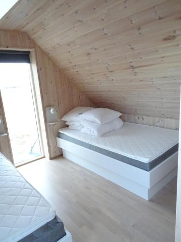SandurCaptains Cottage的木天花板的客房内的一张床位