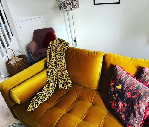 墨尔本Luxury 2 bed cottage in the centre of Melbourne的一张黄色的沙发,上面有豹子毯子