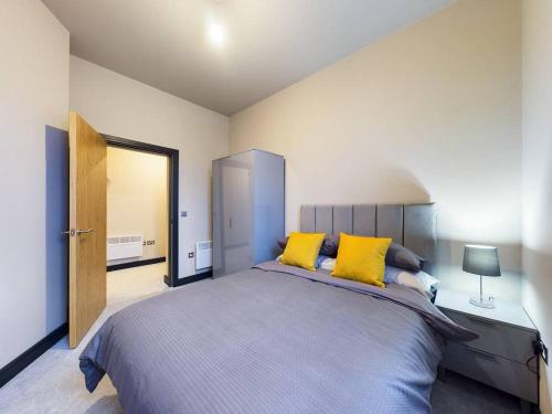 沃勒西Gibson Manor Apartment 10的一间卧室配有一张带黄色枕头的大床