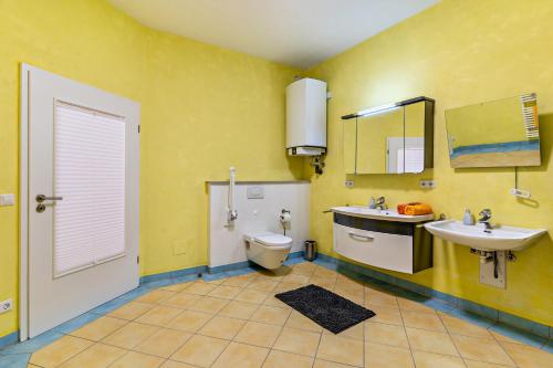 霍恩贝格Ferienhaus Brigitte的黄色的浴室设有卫生间和水槽