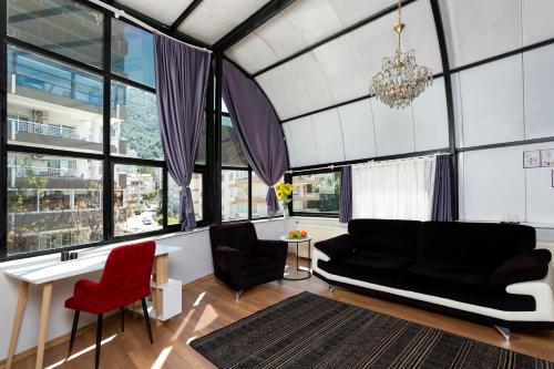 Balçova8 Rooms House的客厅配有黑色沙发和红色椅子