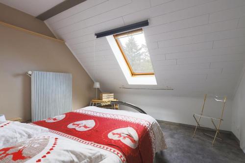 WeiterswillerGîte Le Bijou et Spa的阁楼上的卧室设有一张床,设有窗户