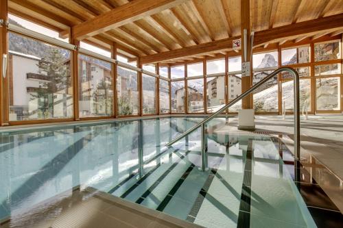 采尔马特采尔马特大都会Spa酒店的一座带窗户的建筑中的游泳池