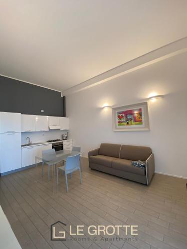 卡梅拉诺Tramonto - Le Grotte Rooms & Apartments的客厅配有沙发和桌子