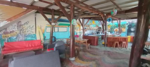 希门尼斯港OSA SURF HOSTAL的客厅配有红色沙发和壁画