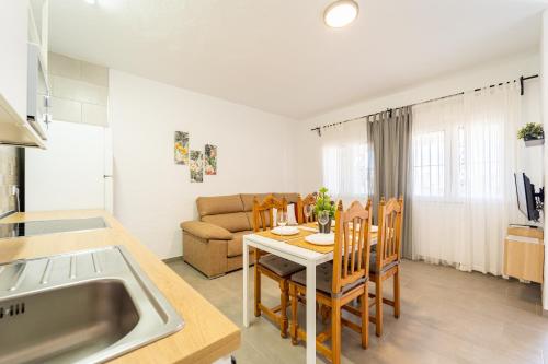 扎霍拉Apartamento Jibazahora P6 - Primera Planta的厨房以及带桌子和沙发的客厅。