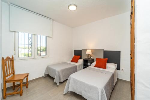 扎霍拉Apartamento Jibazahora P6 - Primera Planta的客房设有两张床、一把椅子和两个窗户。