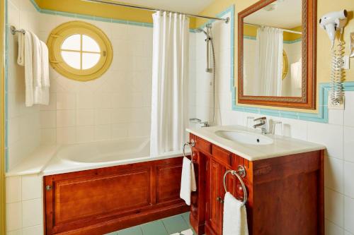 贝利罗曼维利而2 Bedrooms Apartment at Village D'ile De France的一间带水槽、浴缸和镜子的浴室