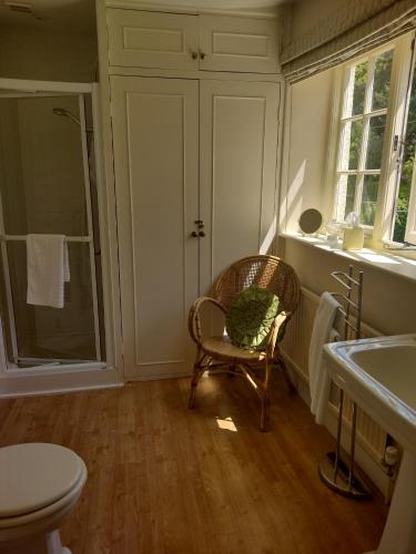 锡德茅斯巴克利乡村旅馆的一间带椅子、卫生间和水槽的浴室