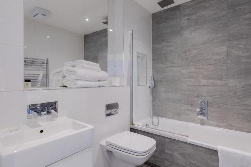 伦敦阿尔德盖特城市公寓的白色的浴室设有卫生间和水槽。