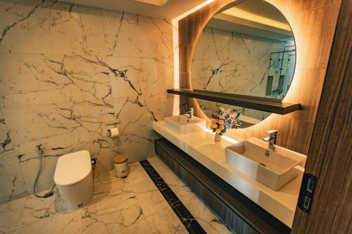 农布Astro Luxury: Ultra Luxury 4 Beds Pool Villa的一间带水槽、镜子和卫生间的浴室