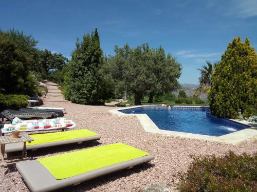 贝尼曼特利Torre de Arriba Casa Rural的游泳池旁设有躺椅