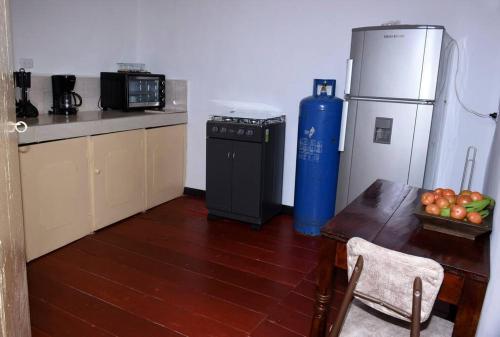 SalaminaCasa típica Salamineña的厨房配有桌子、冰箱和桌子。