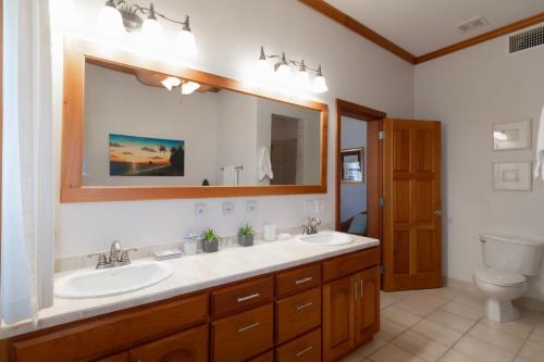 圣佩德罗Tara Del Sol Resort的一间带两个盥洗盆和大镜子的浴室