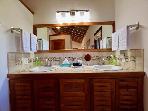 珀拉什奇亚Bella Sway Belize的一间带两个盥洗盆和大镜子的浴室