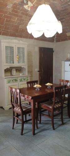 OlivolaLa casa dei limoni的用餐室配有桌椅和白色天花板