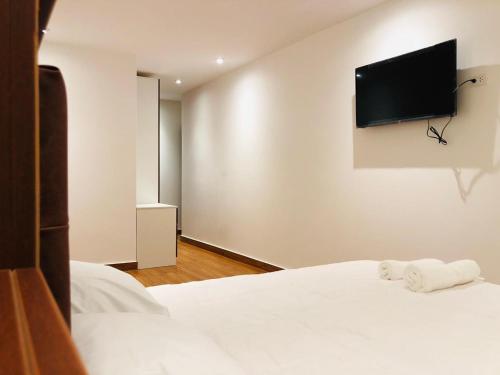 卡哈马卡Hotel Silva Inn的卧室配有一张床铺,墙上配有电视