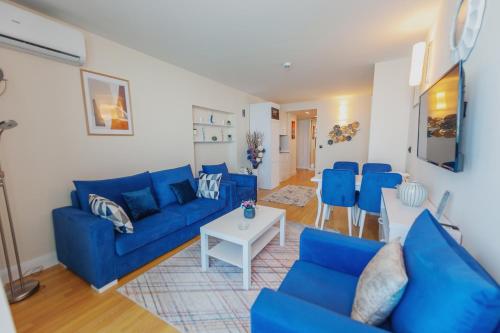 巴统ORBI CITY APART HOTEl的客厅配有蓝色的沙发和桌子