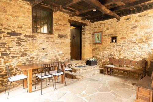 VilarCASA GRANDE VILAR的配有桌椅和石墙的房间