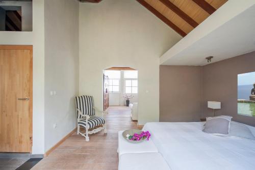 奥拉涅斯塔德Villa L'Oasis的卧室配有一张白色大床和一把椅子