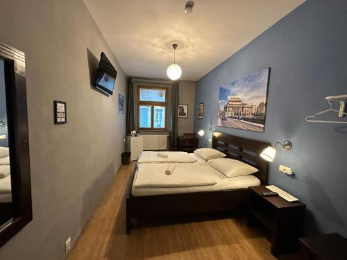 布拉格中央一室公寓的一间卧室设有一张床和蓝色的墙壁