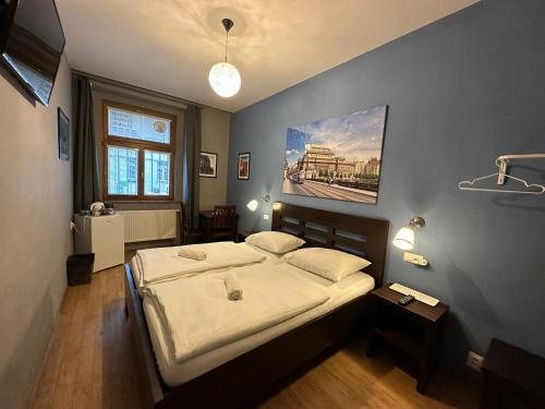 布拉格中央一室公寓的卧室配有一张床,墙上挂着一幅画