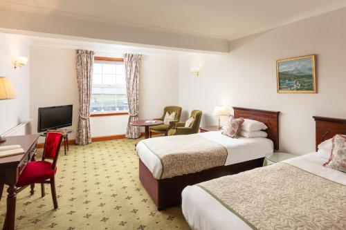 斯特兰拉尔西北城堡酒店的酒店客房设有两张床、一张桌子和一台电视。